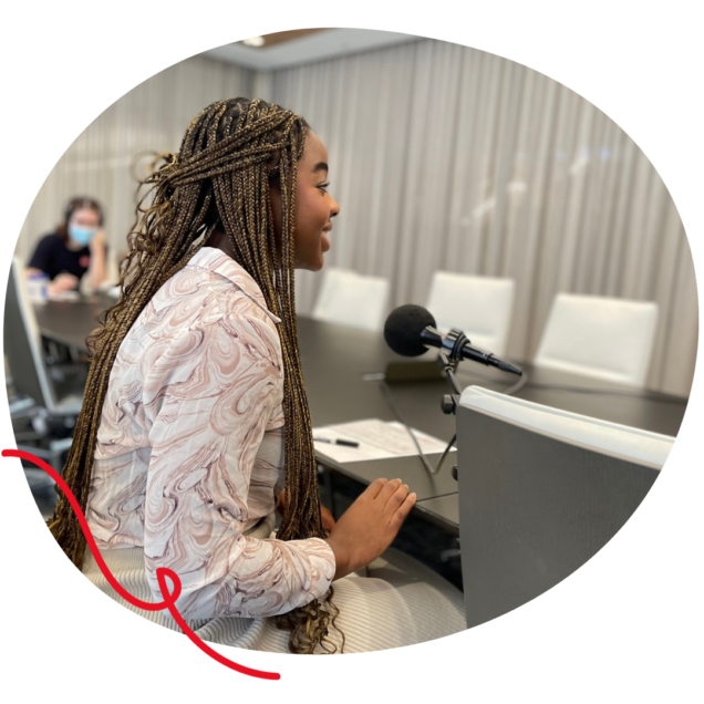 A young Black girl with long brown and black braids in a brown and white swirl button down.